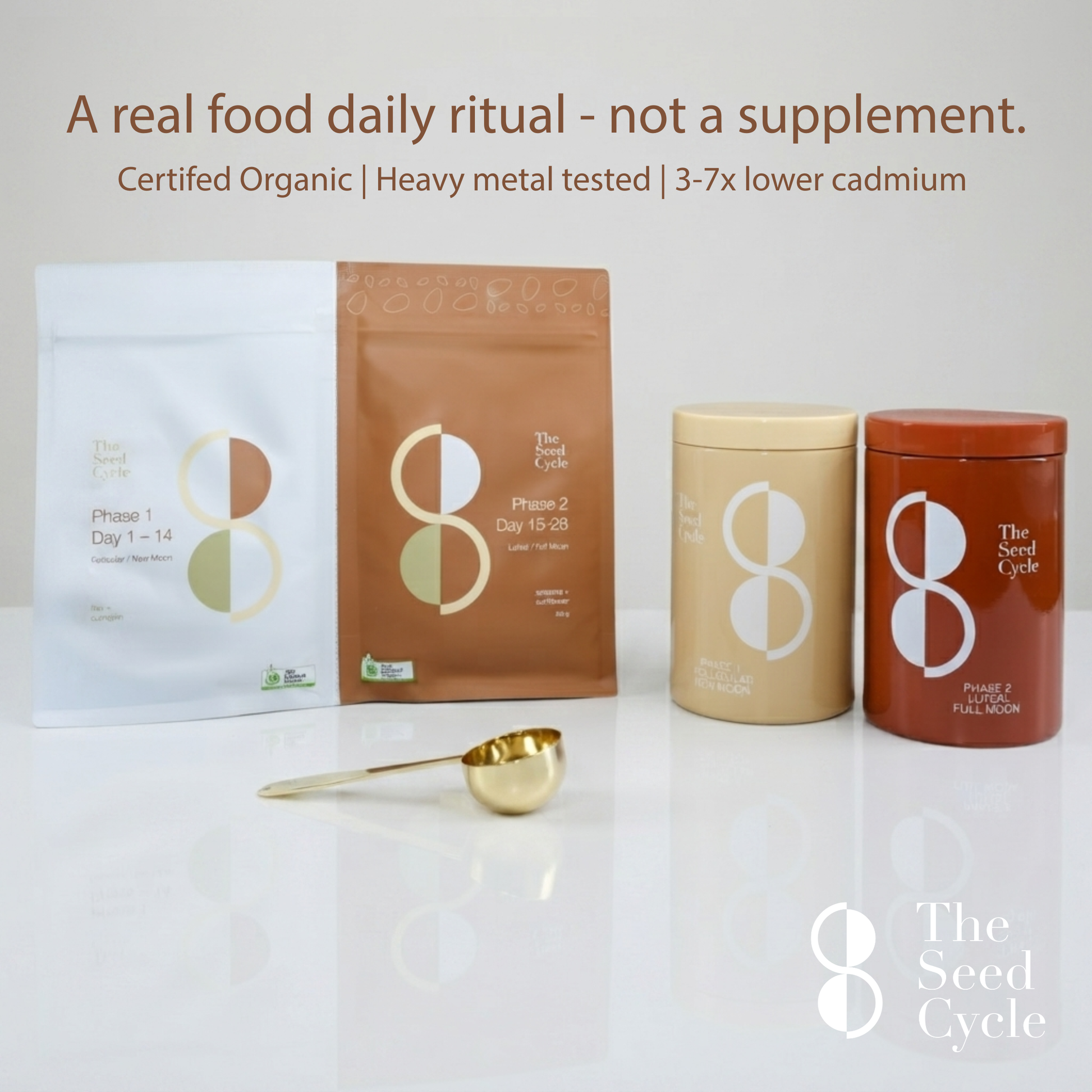 Four supplement containers and two sachets from The Seed Cycle are arranged on a white surface with a small gold scoop in front. The products include white, brown, beige, and reddish-brown packaging with large white and gold circular logos.